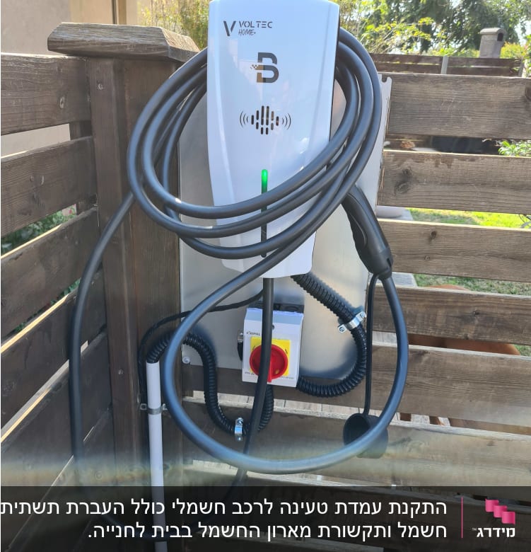 מטען חשמלי לרכב עם כבל תלוי על קיר עץ